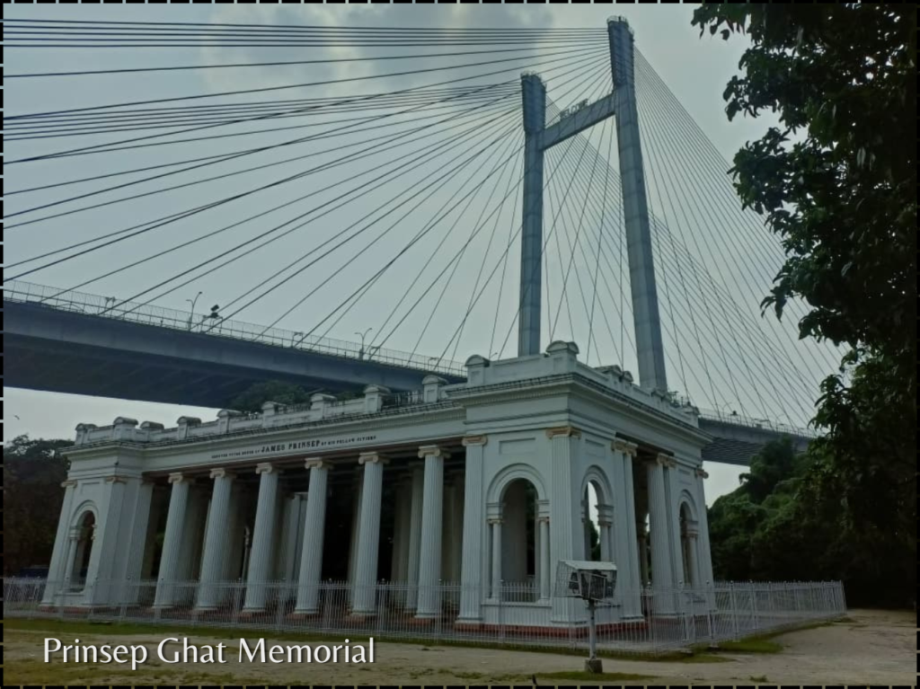 The white Palladian-style James Prinsep Memorial with its tall fluted columns, situated in front of the modern cable-stayed Vidyasagar Setu bridge in Kolkata.